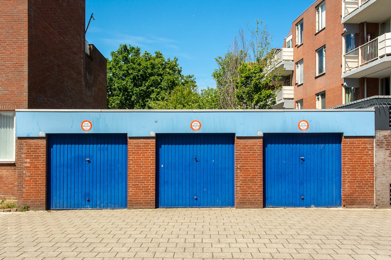 Garagem de condomínio com portas azuis, exemplo de zona limpa